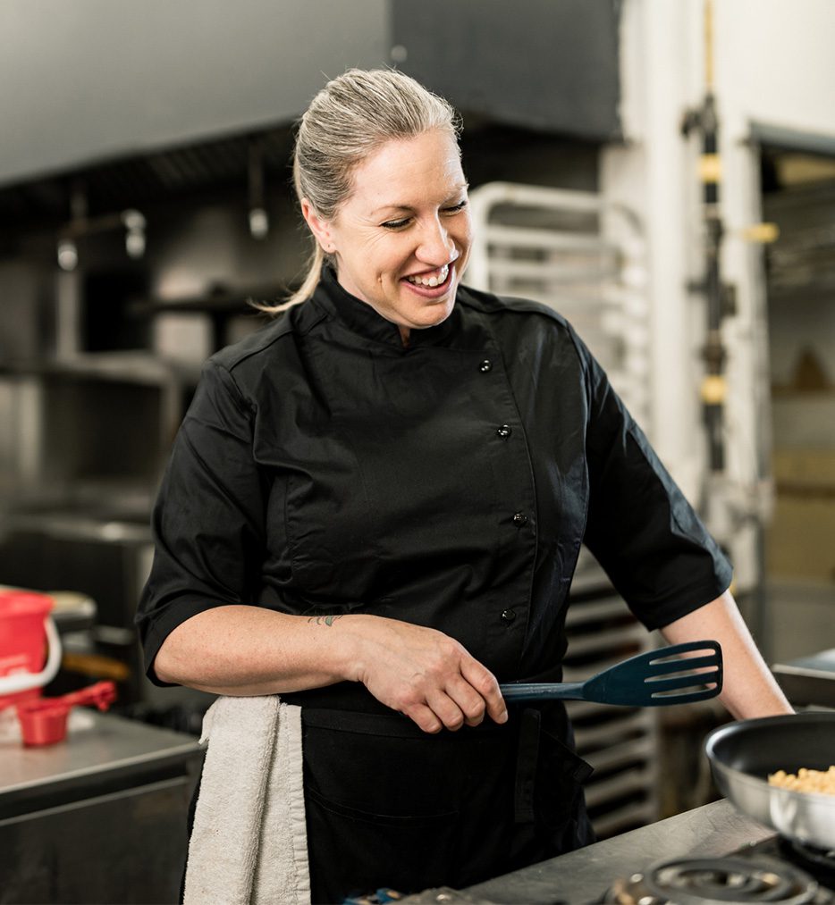 Female chef in black apron.